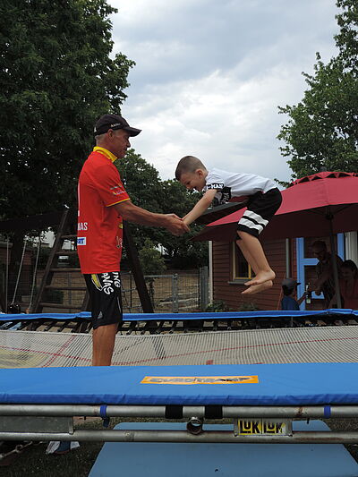 Sommerfest 2023. Vater mit Kind auf dem Trampolin