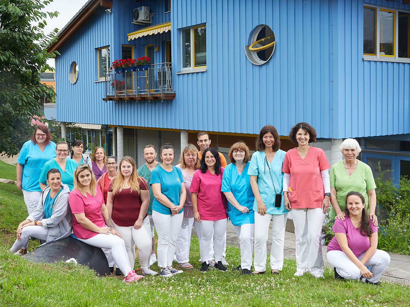 Eine Gruppe von Frauen und Männern vor einem Gebäude.