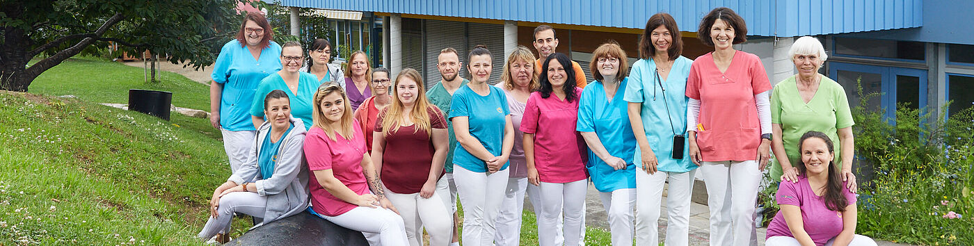 Eine Gruppe von Frauen und Männern vor einem Gebäude.